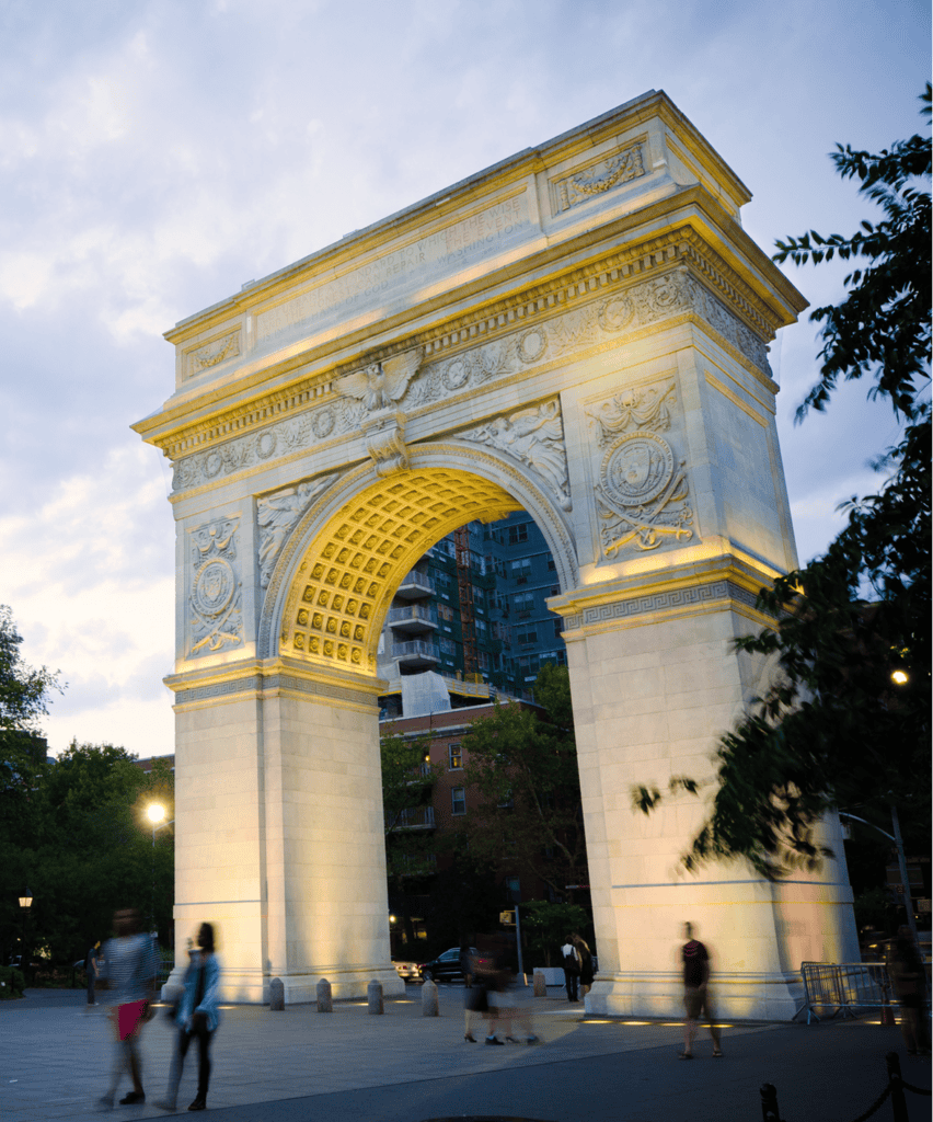 Washington Square Arch, a marble monument with yellow-gold trim and ornate detailing, stands.
